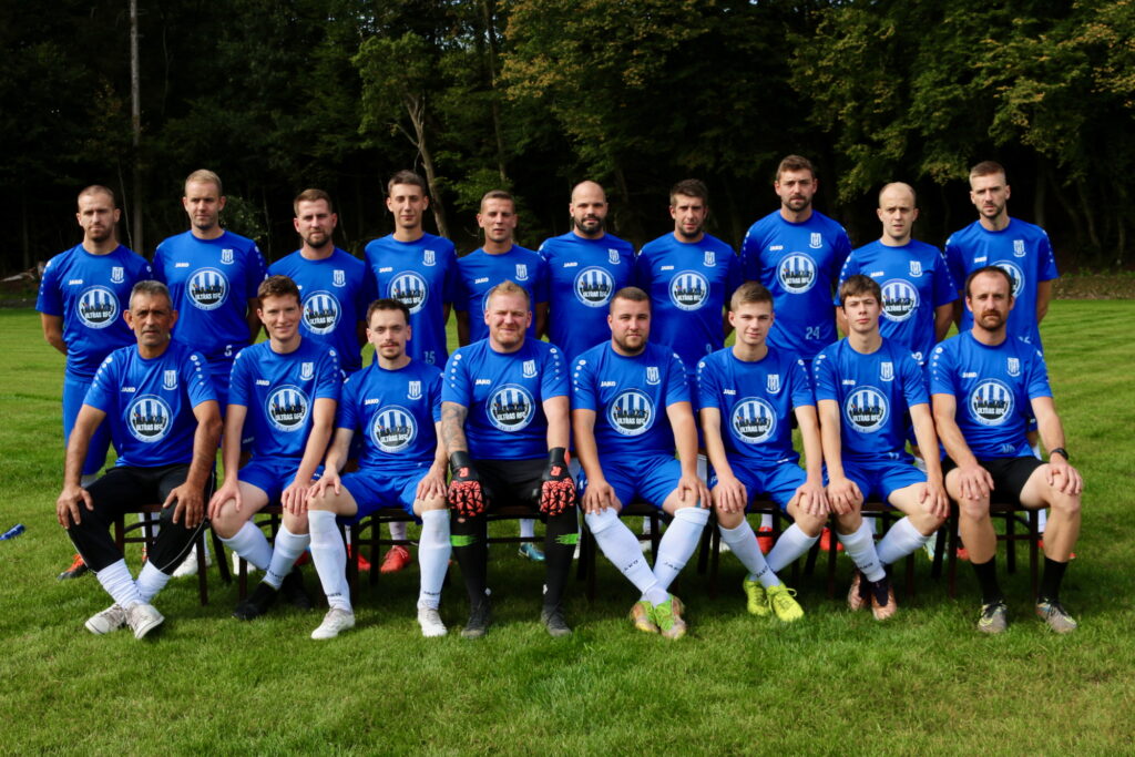 Photo d'équipe première du RFC Grandvoir avec maillots d'échauffement Ultras RFC